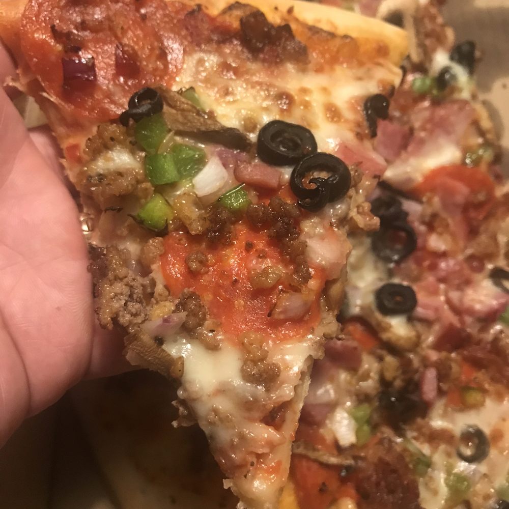 Bulldogs Pizza - a hand holding a slice of pizza - Pizza Near Me - Spring, Texas Bulldogs Pizza - a hand holding a slice of pizza - Pizza Near Me - Spring, Texas
