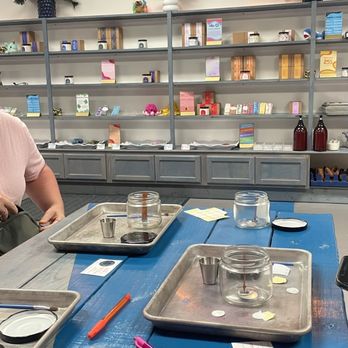 Lucid Coast - a woman sitting at a blue table - Candle Stores Near Me - Myrtle Beach, South Carolina
