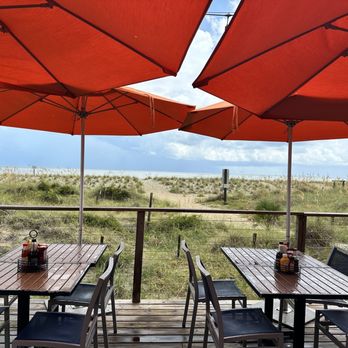 The Deck - tables and umbrellas on a sunny day - New American Near Me - Tybee Island, Georgia