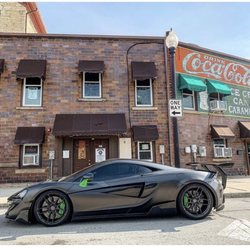 The Detail Haus - McLaren wrapped in a Satin Dark Grey (Nero) with green calipers and accents.