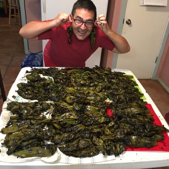 Hot Damn Chiles - a man sitting in front of a table full of chilis - International Grocery Near Me - Hatch, New Mexico