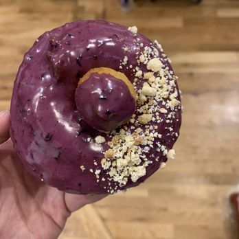 Pandemic Donuts - a hand holding a purple donut - Donuts Near Me - Denver, Colorado