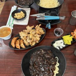 Vegan black bean noodles, tofu, dumplings, fried pork, dipping sauce, side dishes (onions, radishes, kimchi), regular black bean noodles. Vegan black bean noodles, tofu, dumplings, fried pork, dipping sauce, side dishes (onions, radishes, kimchi), regular black bean noodles.