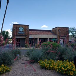 a coffee shop with a clock on the side of the building