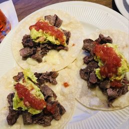 Three carne asada tacos med rare w fresh guacamole. Three carne asada tacos med rare w fresh guacamole.