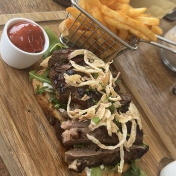 Views Restaurant - Steak sandwich with Maui onion crisps and arugula served open face on sourdough bread with fries. - American Near Me - Lanai City, Hawaii Views Restaurant - Steak sandwich with Maui onion crisps and arugula served open face on sourdough bread with fries. - American Near Me - Lanai City, Hawaii