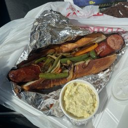 Spicy Smoked sausage sandwich with the peppers and onions, potato salad side Spicy Smoked sausage sandwich with the peppers and onions, potato salad side