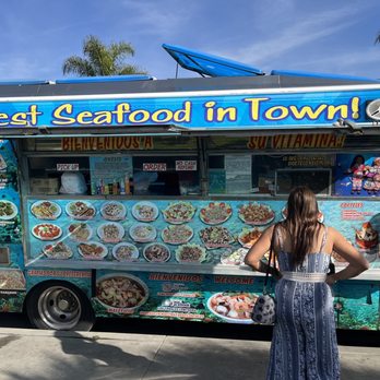 Mariscos Los Corales - a woman standing in front of a food truck - Food Trucks Near Me Mariscos Los Corales - a woman standing in front of a food truck - Food Trucks Near Me
