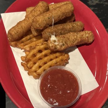 Leonardo's - Mozzarella Stix - Mozzarella sticks, waffle fries, and marinara sauce are served on a red tray with a paper liner, likely at a casual restaurant. - Pizza Near Me - Cedar Rapids, Iowa