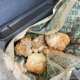 Boneless Wings - Six pieces of fried chicken with breading are placed in a paper-lined container, likely from a fast-food restaurant.