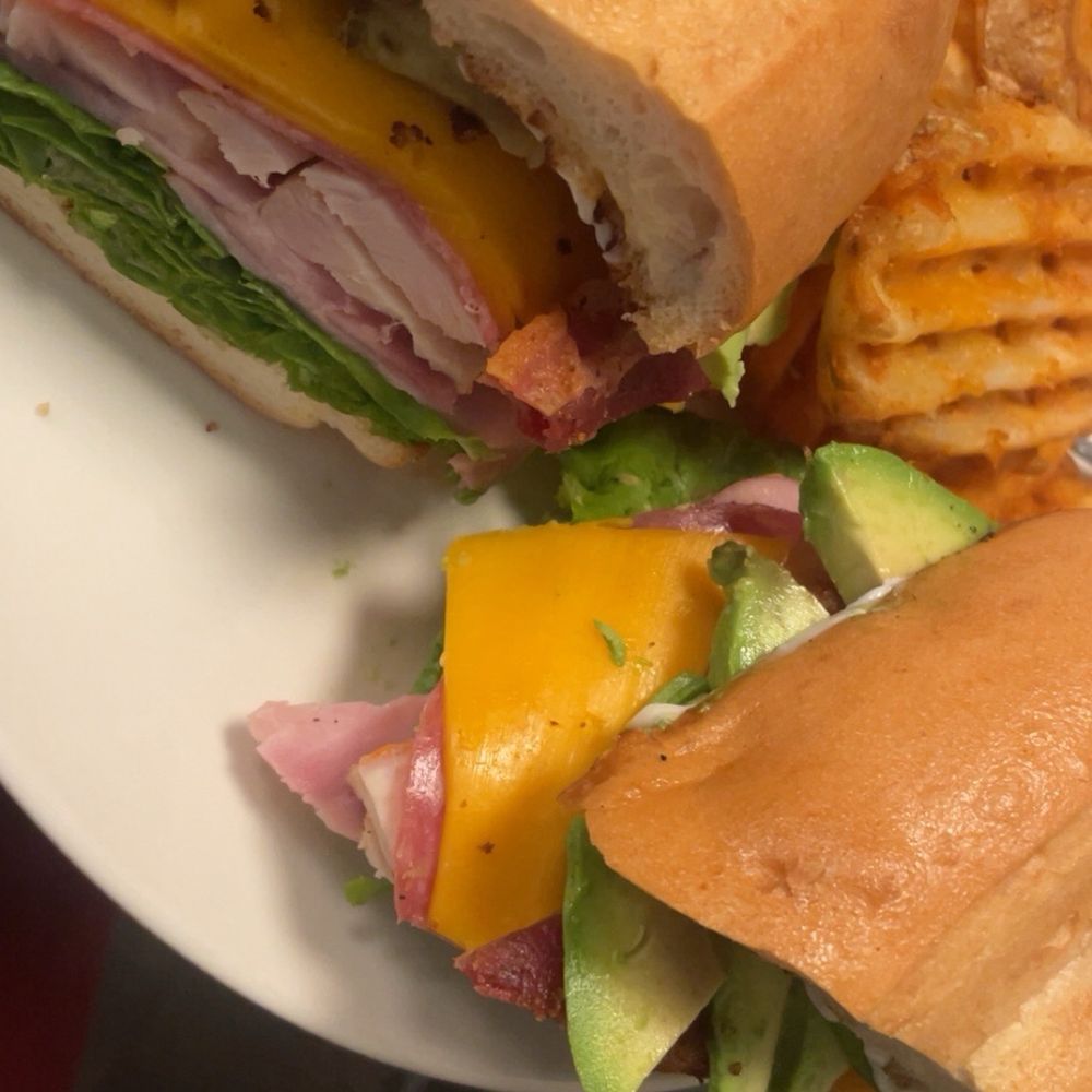 Club sandwich with avocado and side of waffles fries Club sandwich with avocado and side of waffles fries
