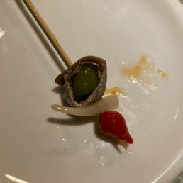 An anchovy pintxo (Gilda-style) with pickled ramp, smoked olive and a sweet pepper An anchovy pintxo (Gilda-style) with pickled ramp, smoked olive and a sweet pepper