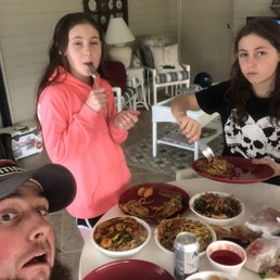 a group of people sitting around a table full of food a group of people sitting around a table full of food