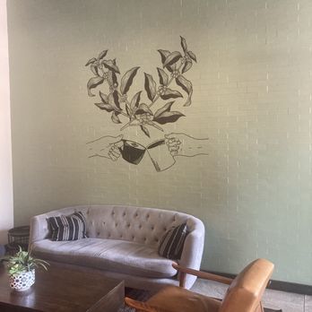 Sip Stir Coffee House - Coffee plant mural with hands toasting their coffee mugs above a velvet sofa. - Coffee & Tea Near Me - Dallas, Texas Sip Stir Coffee House - Coffee plant mural with hands toasting their coffee mugs above a velvet sofa. - Coffee & Tea Near Me - Dallas, Texas