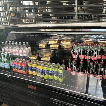 Creampuff - A glass-front refrigerated display case contains bottled sodas, water, and pre-packaged desserts, situated in a public setting. - Donuts Near Me - Phoenix, Arizona