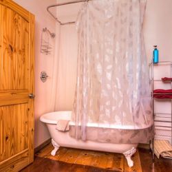 DiamondStone Guest Lodges - Upstairs 2-Queen Suite has full bath with clawfoot shower/tub.