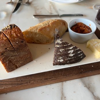 Spago - The assorted breads with sea salt butter and a dipping sauce. - New American Near Me - Las Vegas, Nevada