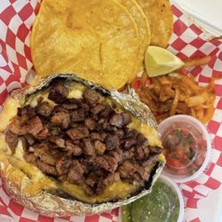 La Fogata Tacos & Papas Asadas - Grilled Baked Potato with carne asada, tortillas, grilled onions and salsas.