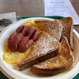 Two Eggs with Beef Sausage - A plate of French toast topped with powdered sugar, served with scrambled eggs and sausage links, at a breakfast restaurant.