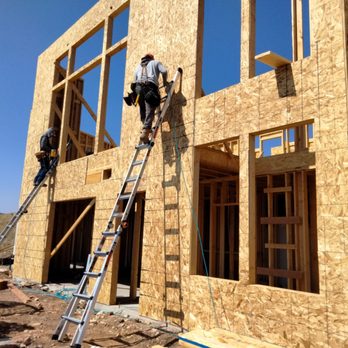 TMJ Construction Services - a man on a ladder working on a house - General Contractors Near Me