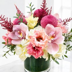 Flowers by Valli & Events - Pale pink orchids with cream hydrangeas, ruffled carnations and magenta mums in a clear glass vase-romantic, cheerful bouquet for anni......