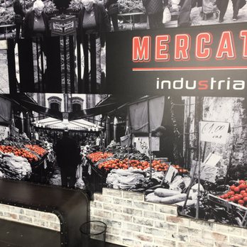 Industria Pizzeria + Bar - a man standing in front of a display of tomatoes - Bars Near Me - Anjou, Quebec