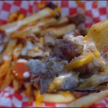 Mr Pork - One dip of a fork shows all of the cheesy goodness the "Mr. Pork Sausage Loaded Fries" has to offer. - Caterers Near Me