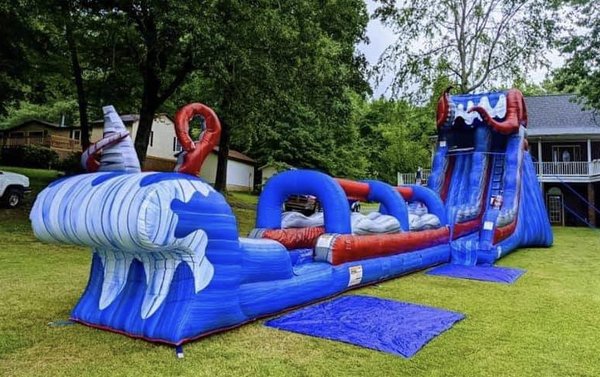 Water Slides - Beat the heat and bring a splash of fun to your party with our inflatable water slides. Jump With Chris water slides come in various sizes and designs—from gentle slopes for younger kids to towering slides that thrill older guests. Our water slides are made of durable materials and include safety features like no-slip surfaces and secure landings. They’re a surefire way to keep everyone cool, entertained, and excited during those warmer months. Let us handle the setup, so you can sit back and watch the laughter and smiles flow all day long. Water Slides - Beat the heat and bring a splash of fun to your party with our inflatable water slides. Jump With Chris water slides come in various sizes and designs—from gentle slopes for younger kids to towering slides that thrill older guests. Our water slides are made of durable materials and include safety features like no-slip surfaces and secure landings. They’re a surefire way to keep everyone cool, entertained, and excited during those warmer months. Let us handle the setup, so you can sit back and watch the laughter and smiles flow all day long.