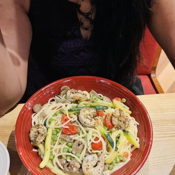 Carrabba's Italian Grill - a woman sitting at a table with a plate of food - Italian Near Me - Panama City, Florida Carrabba's Italian Grill - a woman sitting at a table with a plate of food - Italian Near Me - Panama City, Florida