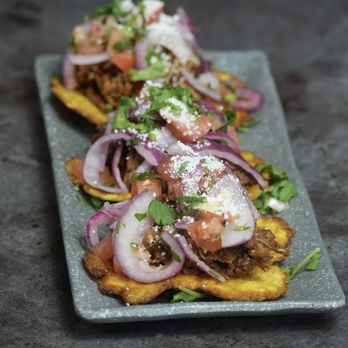 La Vecina - Ropa Vieja Tostone Bites - crispy plantains topped with shredded beef, curtido, and cotija at La Vecina Astoria - Cocktail Bars Near Me - Astoria, New York La Vecina - Ropa Vieja Tostone Bites - crispy plantains topped with shredded beef, curtido, and cotija at La Vecina Astoria - Cocktail Bars Near Me - Astoria, New York