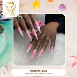 La Vela Nail Lounge - Dramatic stiletto extensions feature a vibrant pink base and clean white line details. Sparkling rhinestones add an elegant edge. Book!