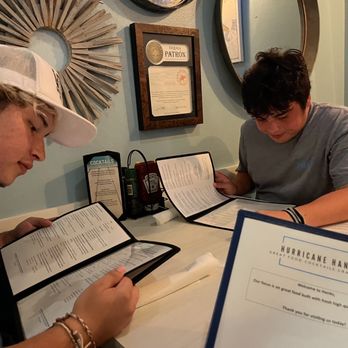 Hurricane Hanks - Sean and Caleb reading a menu. - American Near Me - Holmes Beach, Florida Hurricane Hanks - Sean and Caleb reading a menu. - American Near Me - Holmes Beach, Florida