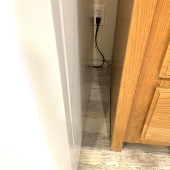 Quality Flooring Pros - Visible gap between the cabinet and baseboard along side refrigerator. - Flooring Near Me