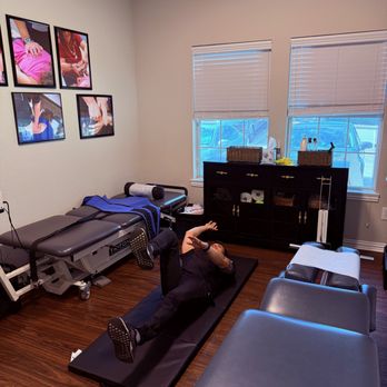 Brain Body Connection Chiropractic - Showing a patient how to do exercises to strengthen a weak area. - Chiropractors Near Me - Denton, Texas