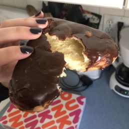 a person holding a half eaten donut a person holding a half eaten donut