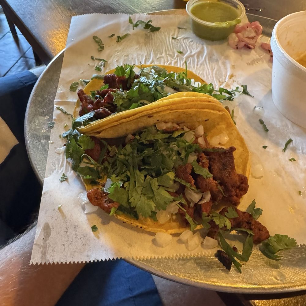 Al pastor Mexican street tacos with elote, halfway done.