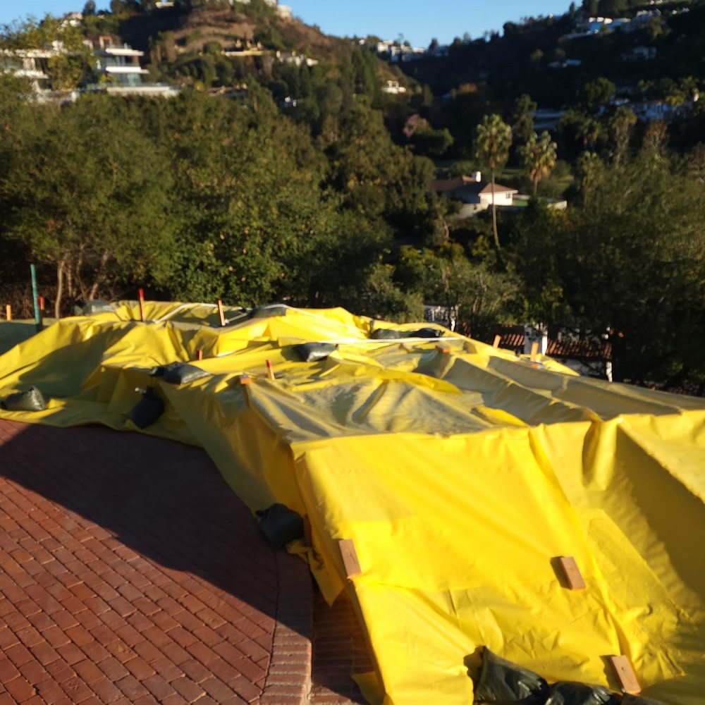 tarped hillside with sandbags and stakes tarped hillside with sandbags and stakes
