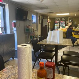 a table with a roll of toilet paper and two bottles of sauce a table with a roll of toilet paper and two bottles of sauce