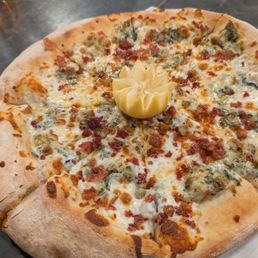 Artichoke dip pizza with bacon, lemon wedge on top. It was a special pizza but very good actually Artichoke dip pizza with bacon, lemon wedge on top. It was a special pizza but very good actually