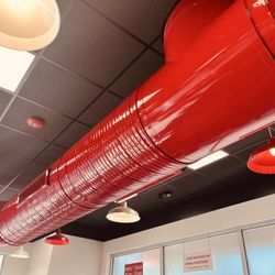 Five Guys - Bright-red industrial pipe on the ceiling of Five Guys.