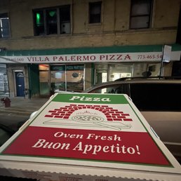 a pizza box in front of a pizza shop a pizza box in front of a pizza shop