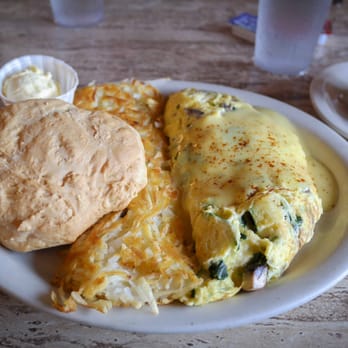 Sybil's Omelettes - Sybil's signature omelette with spinach, zucchini, mushrooms, cheddar, and Hollandaise, pictured with a homemade biscuit. - Breakfast & Brunch Near Me - Salem, Oregon