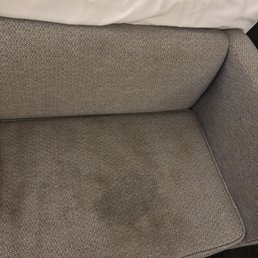 Stained couch on the end of one of the double beds Stained couch on the end of one of the double beds