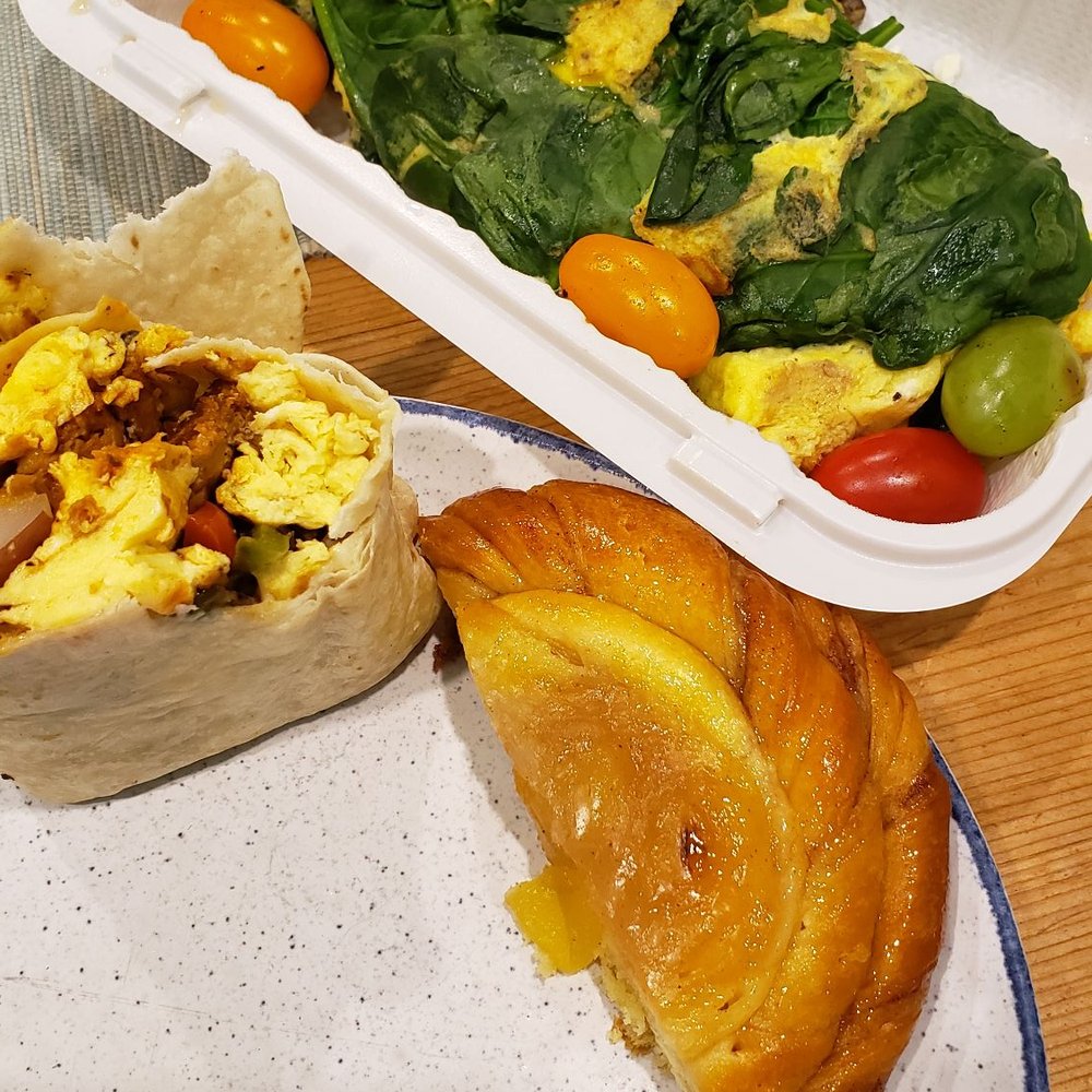 a plate of food and a container of salad a plate of food and a container of salad