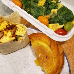 a plate of food and a container of salad a plate of food and a container of salad