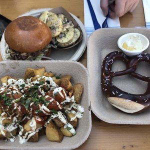 Photo of Wursthall - San Mateo, CA, United States. Wood fire pretzel, curry wurst with triple fried potatoes, and smash burger with potato salad.