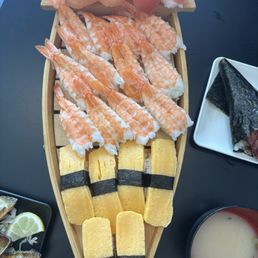 Mini sushi boat from all you can eat - tamago nigiri, ebi nigiri, ahi nigiri and salmon nigiri - sides: miso soup, baked muscles and spam Mini sushi boat from all you can eat - tamago nigiri, ebi nigiri, ahi nigiri and salmon nigiri - sides: miso soup, baked muscles and spam