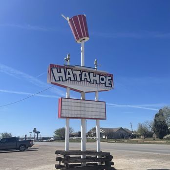 Hatahoe - A retro-style sign for Hatahoe features a large soda cup on top, with a blank message board below, set in a parking lot under a clear blue sky. - New American Near Me - Anson, Texas