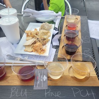 Corbin Farms Winery - a boy sitting at a table with a tray of food and glasses of wine - New American Near Me - Calera, Alabama Corbin Farms Winery - a boy sitting at a table with a tray of food and glasses of wine - New American Near Me - Calera, Alabama