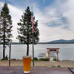 a pint of beer on a table overlooking a lake a pint of beer on a table overlooking a lake